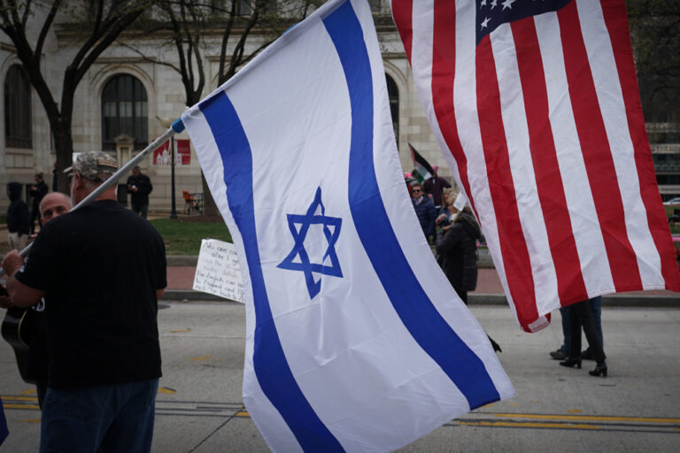 Pessoa segurando as bandeiras de Israel e Estados Unidos 