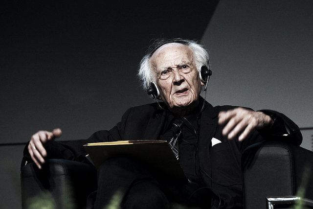 Filósofo Zygmund Bauman sentado em cadeira com livro ao colo